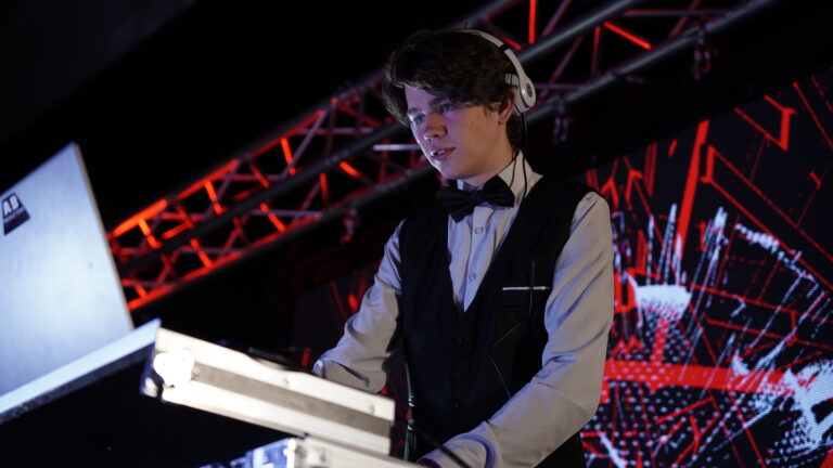 DJ performing live at A & B Productions event with professional sound and lighting setup.