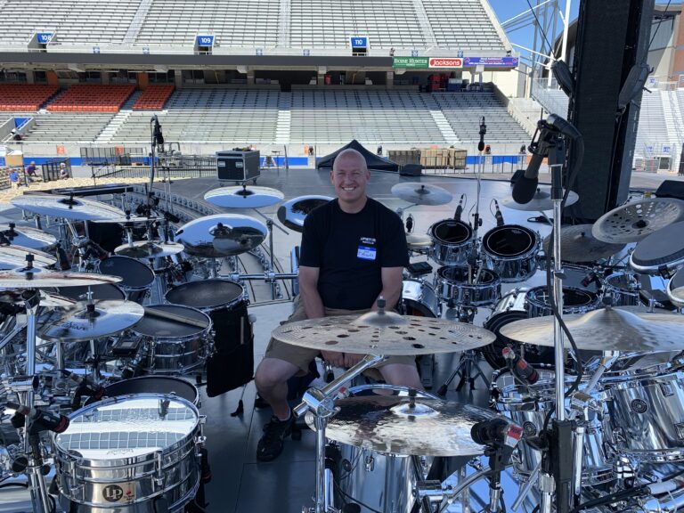 Drummer with drum kits at stadium concert setup.