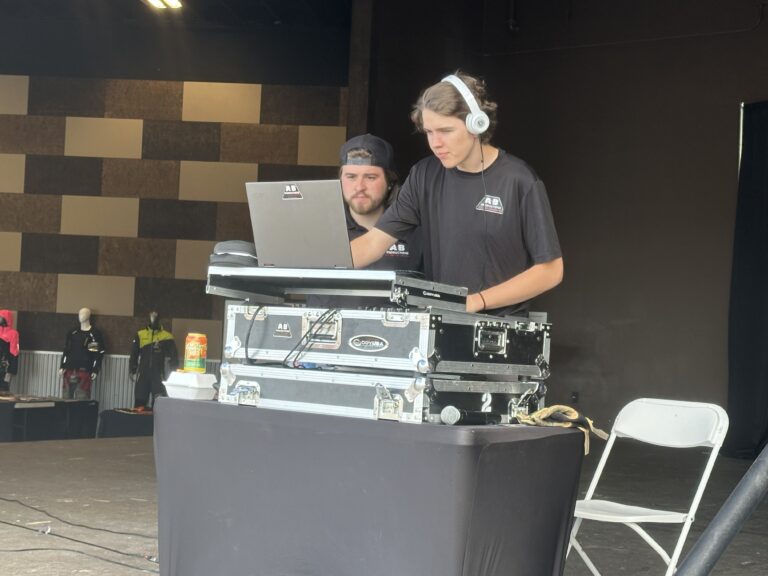A & B Productions DJ setup with two DJs using laptops and sound equipment.