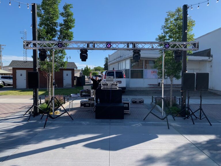 Outdoor DJ stage with professional lighting and sound system for events.