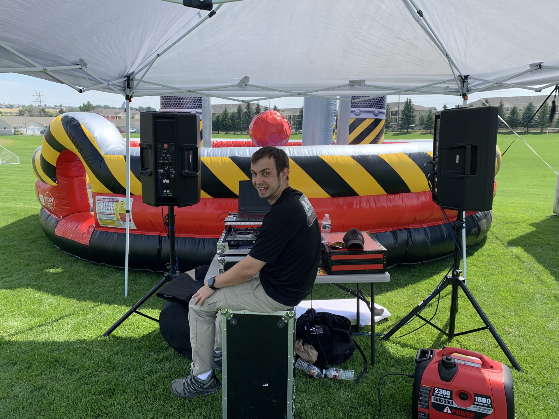 DJ booth with sound equipment at outdoor event by A & B Productions.