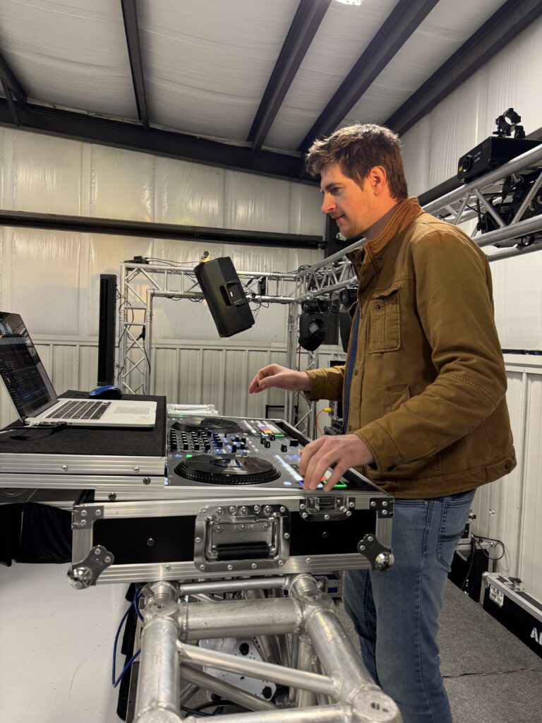 DJ performing at A & B Productions event, professional sound and lighting setup.