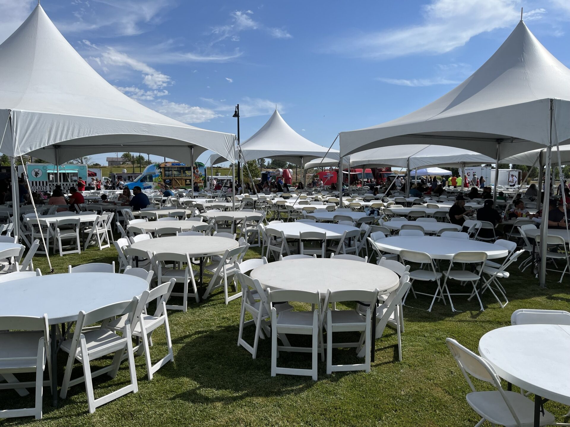 Event tent setup with white tents and tables for outdoor gatherings.