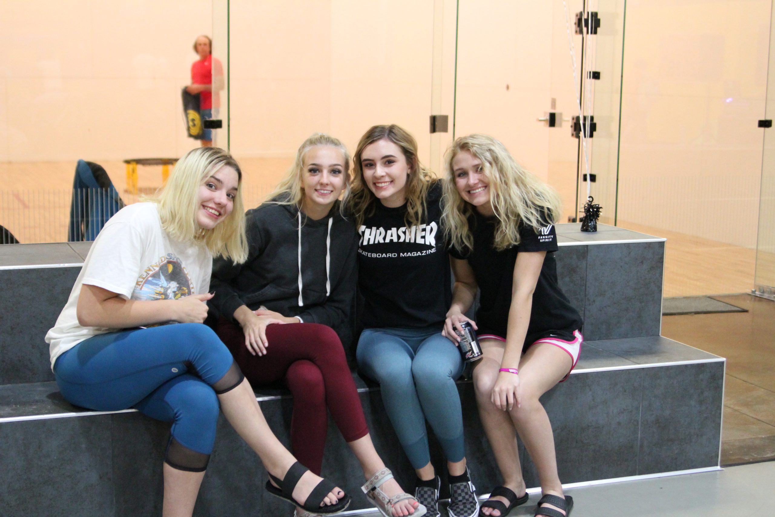 Four students sitting on gym bleachers at a senior all-night party