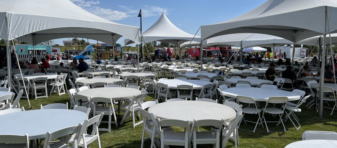 Event tent setup with white canopies and tables for outdoor gatherings.