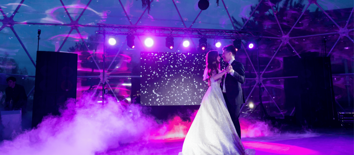 Wedding dance at A & B Productions with colorful stage lighting and fog effects.